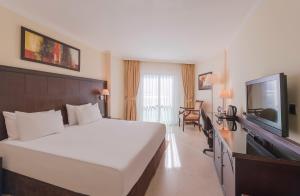 a hotel room with a bed and a flat screen tv at Crowne Plaza Antalya, an IHG Hotel in Antalya