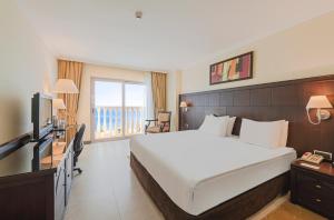 Pokój hotelowy z dużym łóżkiem i telewizorem w obiekcie Crowne Plaza Antalya, an IHG Hotel w mieście Antalya