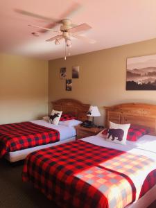 a hotel room with two beds and a ceiling fan at Parkway Motel in Wawa