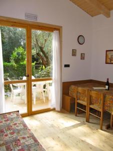 una camera con tavolo e porta scorrevole in vetro di Cottage Heliopolis 89 a Manerba del Garda