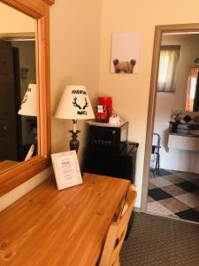 a room with a table with a lamp and a mirror at Parkway Motel in Wawa