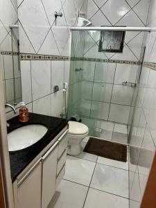 een badkamer met een douche, een wastafel en een toilet bij Casa aconchegante em Araxá in Araxá