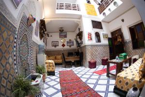 a living room with a tile floor and a room with a table at Dar Amir Fez in Fez
