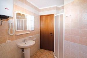 ein Bad mit einem Waschbecken und einem Spiegel in der Unterkunft Wohnungen in Ferienanlage in Bibione