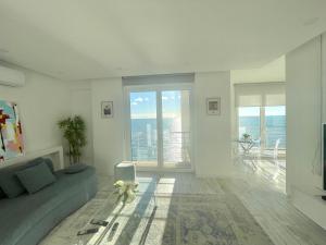- un salon avec un canapé et une grande fenêtre dans l'établissement Durres Currila Modern Luxury STUNNING Beach Views, à Durrës