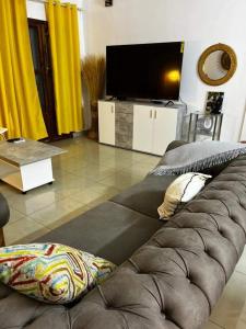 sala de estar con sofá y TV de pantalla plana en Mienmo Residence, en Ouagadougou