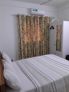 1 dormitorio con cama grande y cortina en Mienmo Residence, en Ouagadougou
