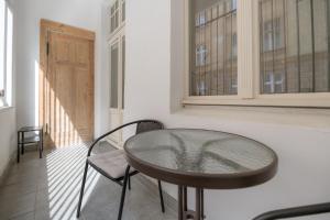 un tavolo con sedie in una stanza con finestre di Cozy studio near Old Town a Toruń