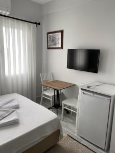ein Schlafzimmer mit einem Tisch und einem TV an der Wand in der Unterkunft İZAN VİLLA BAKIŞ APARTMENTS in Bodrum City