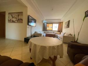 een woonkamer met een tafel en een bank bij Superbe appartement à Marrakech quartier Majorelle 2 chambres in Marrakesh