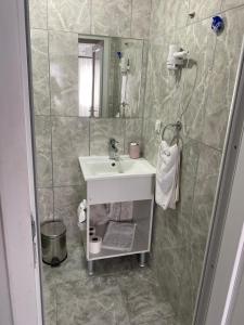 ein Bad mit einem Waschbecken und einem Spiegel in der Unterkunft İZAN VİLLA BAKIŞ APARTMENTS in Bodrum City