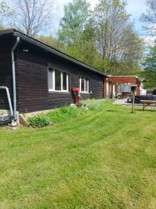 a small house with a yard in front of it at chalet avec jacuzzi in Manhay