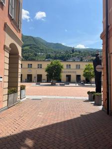 een stenen binnenplaats met een gebouw met een berg op de achtergrond bij B&B Ilien in Bellinzona