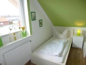 Cama blanca en habitación con ventana en Ferienhaus in Hoben mit Grill und Terrasse, en Zierow