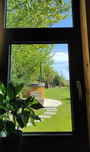 uma janela com vista para um jardim a partir de uma casa em Domek Ponad Mgłami em Laskowa