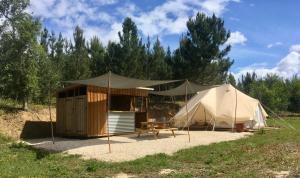 una tienda grande y una mesa en un campo en Tente Glamping nature et océan, Rogil, en Rogil