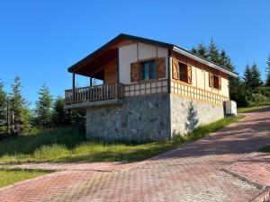 une maison avec un balcon sur le côté d'une route dans l'établissement GÖRNEK TABİAT PARKI, à Trabzon