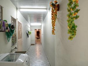 a hallway with flowers hanging on the wall at Casa Lilia 10 minutos Aeropuerto Tocumen in Panama City +42 photos