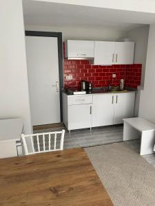 uma cozinha com armários brancos e uma parede de tijolos vermelhos em İZAN VİLLA BAKIŞ APARTMENTS em Bodrum City
