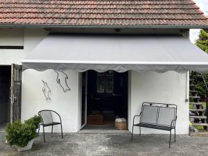 two chairs sitting outside of a house with an awning at Lakeside Studio, Haus mit Seezugang nur fuer Urlauber in Königs Wusterhausen +28 photos