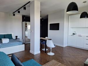a living room with a bed and a table at Apartament Wiejska 9 in Warsaw