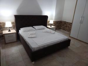 a bedroom with a large bed with two night stands at Apartment TEONA in Sarandë