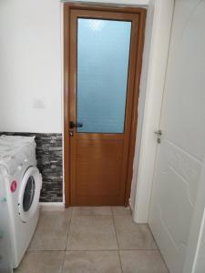 a door in a bathroom with a washing machine at Apartment TEONA in Sarandë +8 photos