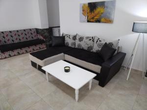 a living room with a couch and a coffee table at Apartment TEONA in Sarandë