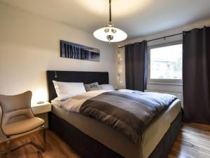 ein Schlafzimmer mit einem Bett, einem Stuhl und einem Fenster in der Unterkunft Ferienwohnung Ostseestern für 4 Personen in Wiek auf Rügen 