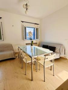 a living room with a glass table and chairs at Serenity House Ornos in Ornos +6 photos