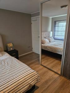 lustro w sypialni z łóżkiem w obiekcie Montana Guest House. w mieście Lillestrøm
