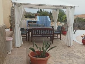 eine Terrasse mit einem Tisch, Stühlen und einem Sonnenschirm in der Unterkunft Villa Paz - Villa Familiar para 6 con piscina, AC, Wifi y parking in Arboleas