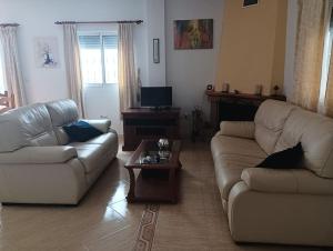 ein Wohnzimmer mit 2 Sofas und einem Couchtisch in der Unterkunft Villa Paz - Villa Familiar para 6 con piscina, AC, Wifi y parking in Arboleas