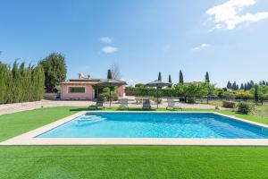 略塞塔的住宿－Ses Veles，一个带椅子的庭院和房子的游泳池