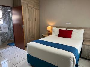 a bedroom with a large bed with a red pillow at Rethabile Guesthouse in Bochum