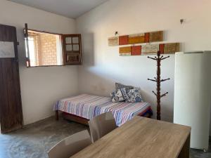 ein kleines Zimmer mit einem Bett und einem Tisch darin in der Unterkunft Casa da Pedra in Bezerros