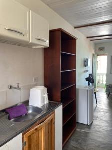 eine kleine Küche mit Spüle und Kühlschrank in der Unterkunft Casa da Pedra in Bezerros