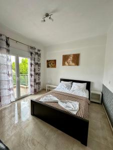 Un dormitorio con una cama grande y una ventana en Villa Spartandom, en Gerakini