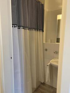 een badkamer met een douchegordijn en een wastafel bij B&B Ilien in Bellinzona