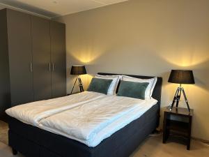 ein Schlafzimmer mit einem großen Bett mit zwei Lampen in der Unterkunft An elegant and exclusive apartment in Bjørvika Oslo in Oslo