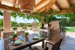 an outdoor patio with a table and a stove at Ses Veles in Lloseta