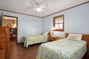 a bedroom with two beds and a ceiling fan at DK390 Tidy Duck in Duck