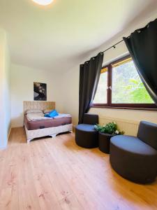 um quarto com uma cama e duas cadeiras e uma janela em Quad room in Am Schöpfwerk area em Viena