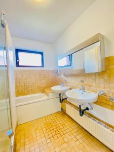 uma casa de banho com 2 lavatórios e um chuveiro em Quad room in Am Schöpfwerk area em Viena