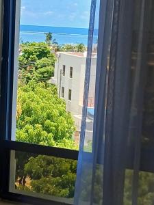 a window with a view of a building and trees at Candy Nyali Sea View Hidden Gem in Mombasa