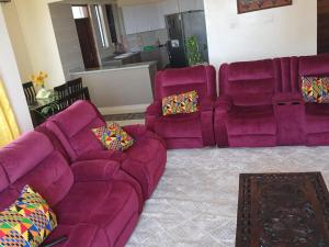 a purple couch and two chairs in a living room at Candy Nyali Sea View Hidden Gem in Mombasa