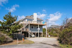 a large house with a deck on a driveway at DK390 Tidy Duck in Duck