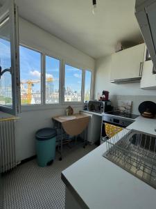 a kitchen with windows and a view of a city at Appartement proche de La Défense in Puteaux