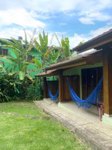 una casa con cortinas azules a un lado. en Pousada Banana Verde, en Ilhabela