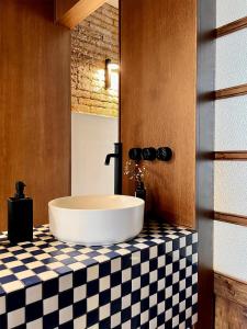 a bathroom with a sink on a checkered counter at El Rincón de María Vicenta in Valencia